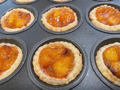 mini peach pies in a muffin tin ready to be baked into the oven