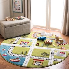 a child's rug with trains and cars on it in a living room next to a window