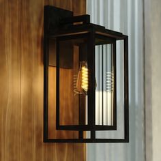 a light that is hanging on the side of a wall next to a wooden door