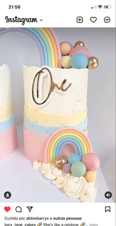 there is a cake decorated with rainbows and balloons on the top, next to a candle