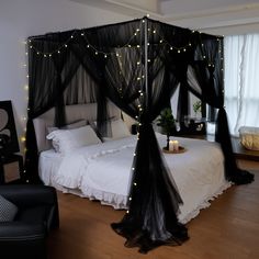 a black canopy bed with lights on it