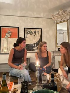 three women sitting on the floor with candles in their hands