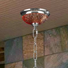 a chandelier hanging from the ceiling in front of a wall with tiles on it