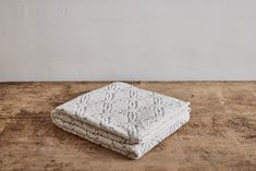 a stack of white towels sitting on top of a wooden table