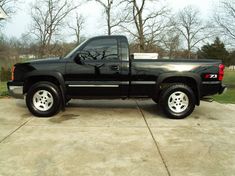 a black pickup truck parked in a driveway