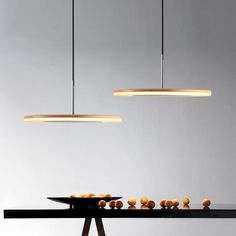 two lights hanging over a table with food on it