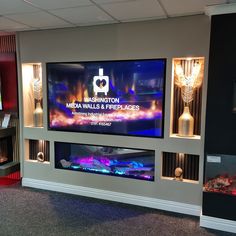 a large television mounted to the side of a wall next to a fire place in a room