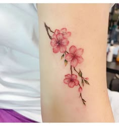 a woman's arm with pink flowers on it