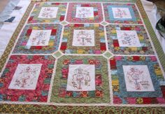 a quilted table topper with many different designs on it