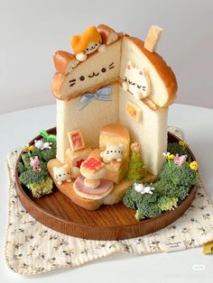 there is a cake shaped like a house with cats and other food items on it