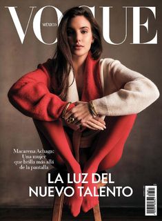 a woman sitting on top of a stool in front of a magazine cover with her arms crossed