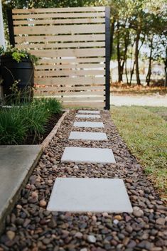 a stone path in front of a wooden fence