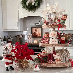 three tiered trays filled with christmas decorations on top of a kitchen countertop