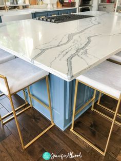 a kitchen island with marble top and gold legs