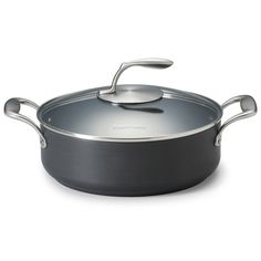 a pan with a lid and handles on a white background, there is also a spoon in the bottom right hand corner