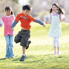 three children are playing with a frisbee in the park