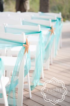 white chairs with blue sashes and starfish decorations