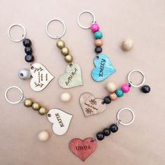 several different types of keychains with hearts and words on them, all hanging from metal rings