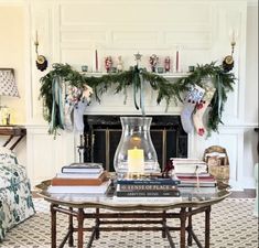 a living room filled with furniture and a fire place covered in christmas garlands next to a fireplace