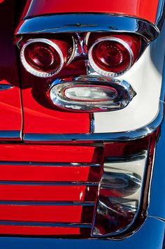 the front end of a red and white classic car