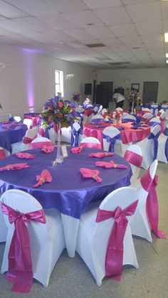 the tables are decorated with purple and white linens, pink sashes, and flowers