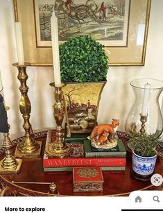 a table topped with books and vases filled with plants