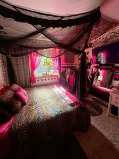 a bedroom decorated in pink and black with a bed covered in leopard print sheets, pillows and curtains