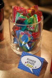 a glass bowl filled with assorted candy on top of a table