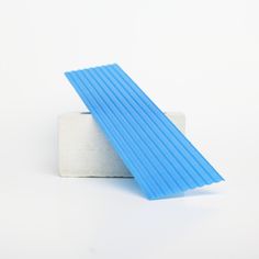 a piece of blue plastic sitting on top of a white surface