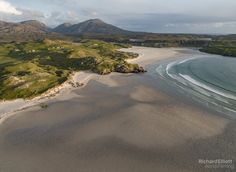 an aerial view of the beach and mountains