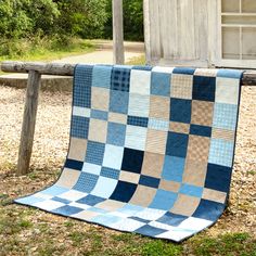 a blue and white quilt sitting on top of a wooden bench