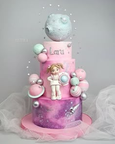 a pink and purple cake with an astronaut on top