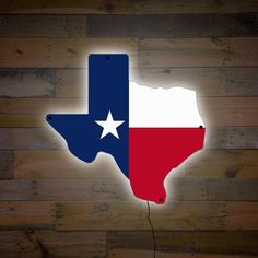 the texas state flag is lit up on a wooden wall