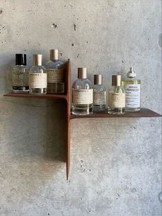 a wooden shelf with bottles on it and two shelves holding different types of perfumes