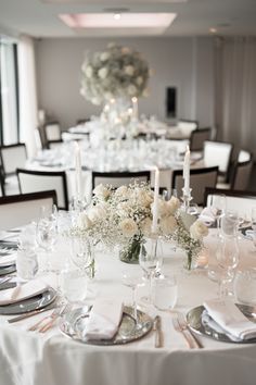 the table is set with white flowers and candles