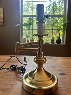 an old fashioned lamp sitting on top of a wooden table