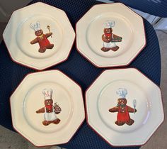 four brown bears on white plates with red trimmings and chef's hats