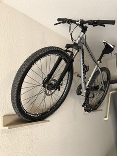 there is a bike hanging on the wall next to it's bicycle rack,