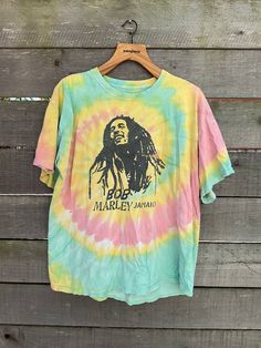 Nicely worn in Bob Marley t-shirt. Classic with a Rasta tie dye. A couple small holes throughout.  Size large Measurements: Sleeve: 7 inches Shoulders: 22 inches Chest: 22 inches Hem: 24 inches Length: 26.5 inches //Policies// We ship out 3-5 days after your purchase. Buyer is responsible for all import fees and duties their individual country applies. All items have been examined and any flaws will be noted in the description. No returns unless items are misrepresented. Measurements are taken f Vintage Tie Dye Washed T-shirt, Vintage Washed Tie-dye T-shirt, Acid Wash Crew Neck T-shirt With Hippie Style, Bleached Multicolor Graphic Tee, Casual Green Festival T-shirt, Acid Wash Cotton Hippie T-shirt, Vintage Distressed Tie Dye T-shirt, Hippie Tie Dye Crew Neck T-shirt, Vintage Hand-dyed Short Sleeve T-shirt