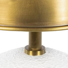 a white and gold table lamp on a white surface