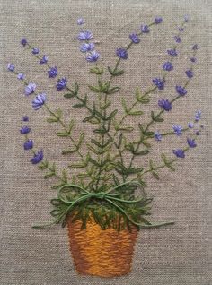 a potted plant with purple flowers on a tan cloth covered tablecloth is shown