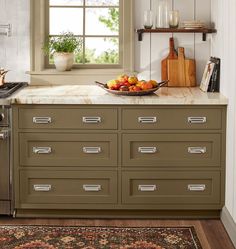 a bowl of fruit is sitting on the counter in this kitchen with an area rug