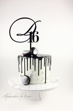 a black and white cake with chocolate drizzles on it's top