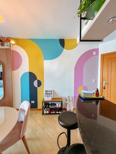 a dining room and kitchen area with colorful wallpaper