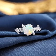 an opalite ring sitting on top of a blue cloth