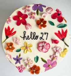 a cake decorated with flowers and the words hello 2 1 on it's side