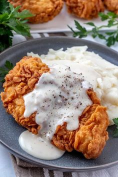 fried chicken with gravy and mashed potatoes on a plate