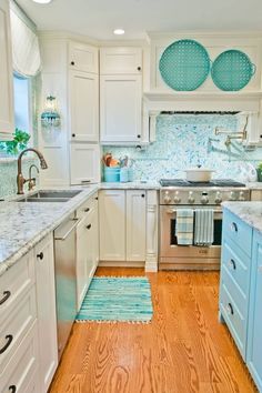 a kitchen with white cabinets and blue accents on the backsplash is pictured in this image