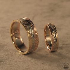 two gold wedding rings sitting next to each other