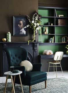 a green chair sitting in front of a fireplace